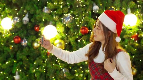Young Woman Takes Selfie Video at Christmas Tree