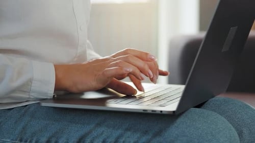 Woman Typing on a Laptop at Home