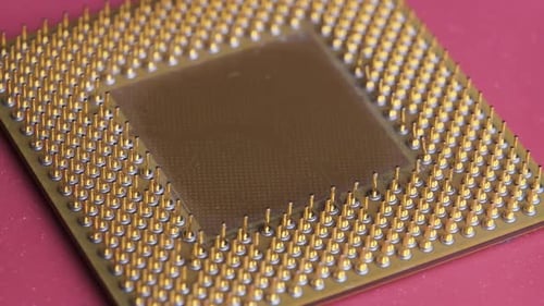 A antiga CPU de processador de computador com contatos banhados a ouro gira em fundo vermelho