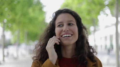 Smiling Woman Chatting on the Phone in City