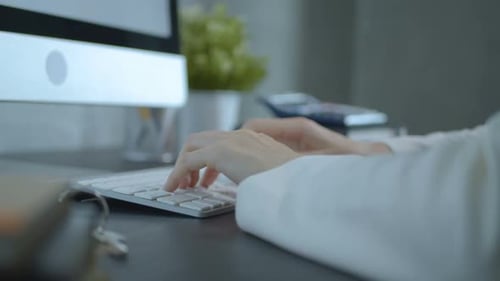Hands Typing on Keyboard in Modern Workplace