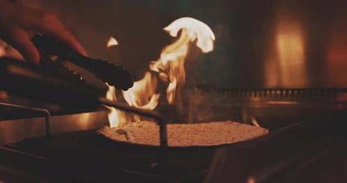 A fire-roasted tortilla flipped on a grill