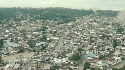 Aerial view going over a large city in South America showing the main street