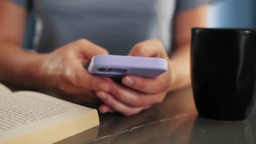Hand of woman using mobile phone, chatting in social media in home morning.