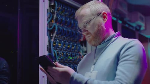 Adult Man Using Tablet in Server Room