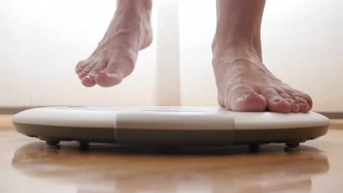 Close-up of woman feets stepping off personal weight measure device 4K 2160p 30fps UltraHD footage