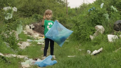 Niña voluntaria limpiando un parque sucio con bolsas de plástico, botellas. Reducir la basura y la contaminación natural