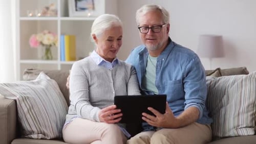 Senior Couple Using Tablet Together on Couch