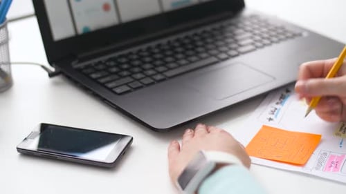 Woman Designs App Interface on Paper at Desk