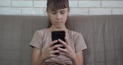 Girl Using Smartphone While Relaxing on Couch