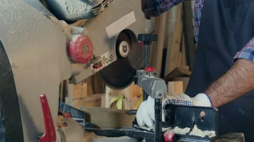Carpenter Using a Circular Saw To Cut a Large Board of Wood in Workshop