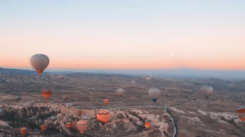 Hot Air Balloons Over Desert Landscape at Sunrise