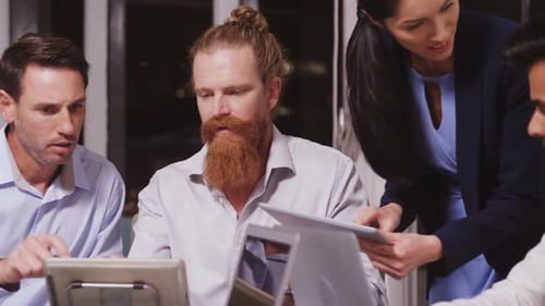 Corporate Team Collaborates on Project at Night