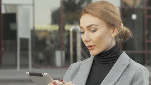 Young Adult Woman Using a Tablet in the City