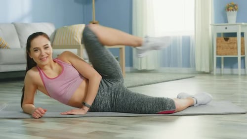Woman Exercising Leg Raises on Yoga Mat Indoors