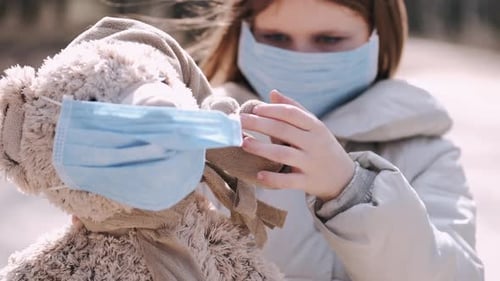 The Girl in a Mask Is Putting a Mask on Teddy Bear Toy