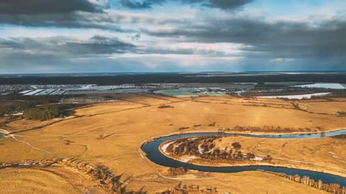 Aerial View Of Dry Meadow And Partly Frozen River Landscape In Sunny Autunn Day