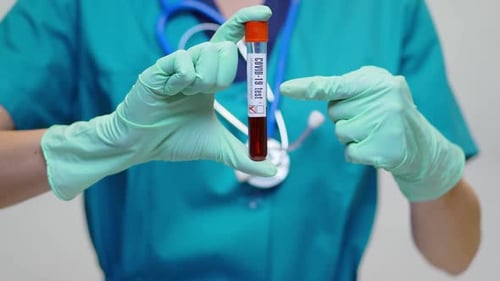 Healthcare Worker Holding COVID-19 Blood Test Vial