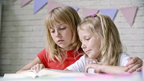 Blond Sisters Reading Book Together