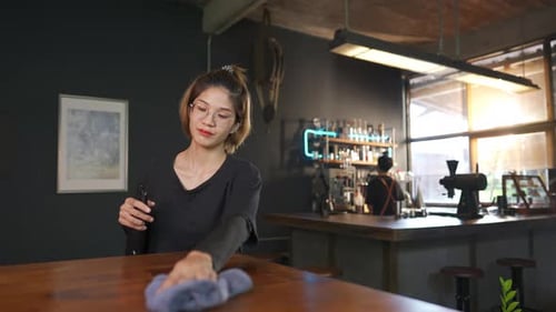 4K Asian woman coffee shop waitress using alcohol sanitizer cleaning counter bar