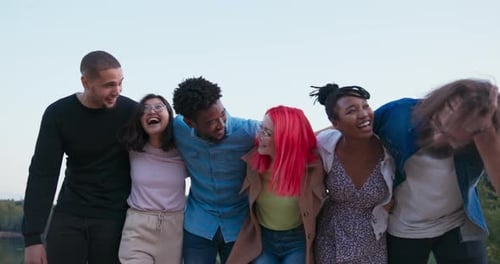 Um grupo de melhores amigos de diferentes nacionalidades se abraçam em uma fileira Seis pessoas sorridentes