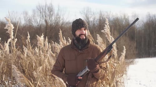 Hunter with Rifle in Snowy Rural Winter Landscape