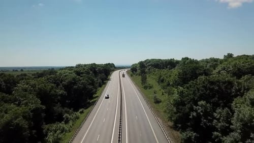 Aerial Shot of a Highway Passing Through the Rural Countryside and Green Forest