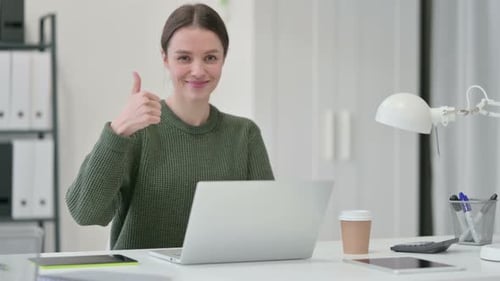 Woman Gives Thumbs Up at Her Desk
