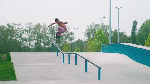 Skateboarder Balancing on Rail in Skatepark