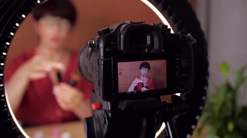 Atractiva bloguera envejecida hace reseñas de productos de belleza para un blog de vídeo da consejos a