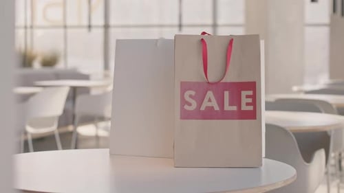 Bolsa de papel con letras rojas de venta en cafetería
