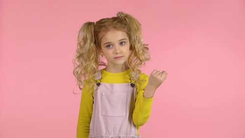 Linda niña se enrolla el pelo en el dedo