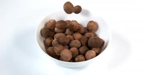 Nutmeg Falling into White Bowl in Slow Motion