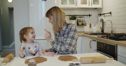 Woman and Girl Bake Cookies in Bright Kitchen