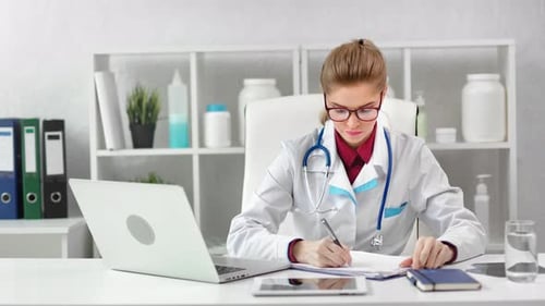 Female Doctor Working at Her Desk in Office