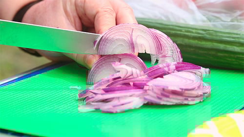 Slicing Red Onion on Cutting Board with Knife
