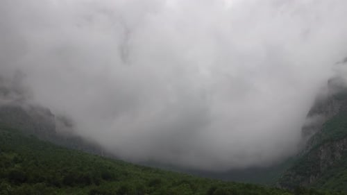 Dramatic Mountainside View with Drifting Fog
