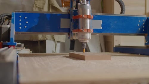 Holzarbeiter schaut auf funktionierende CNC-Maschine