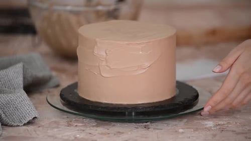 Icing A Cake With Light Brown Frosting