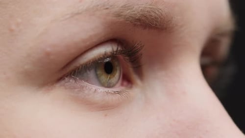 Nahaufnahme eines blinzelnden hellen Auges mit lackierten Wimpern beim Öffnen und Schließen der Augen