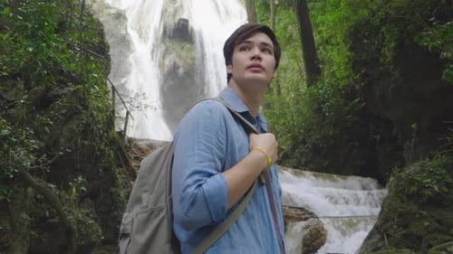 Young Man With Waterfall Deep In The Jungle