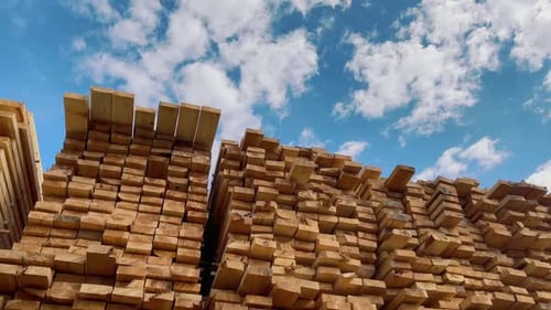 Stacked Lumber Boards Against Blue Sky