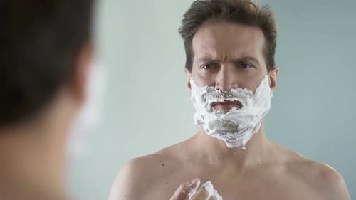 Man Preparing to Shave, Feeling Discomfort and Tingle on Face From Shaving Foam