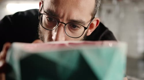 Man Dusting Off a Geometric Shape with Breath
