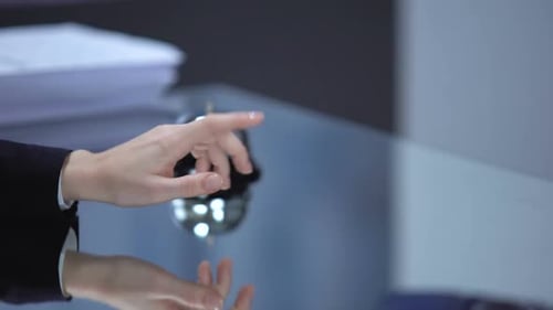 Hand Resting Near Service Bell on Table