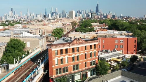 Apartment buildings with a crossing railway and a big city skyline - Drone shot