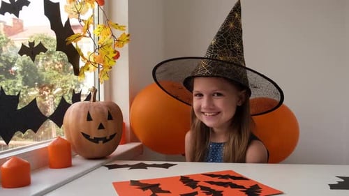 Happy Child in Witch Hat at Halloween Party
