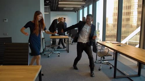 Handsome Man and Sexy Woman in Business Office Dancing After Winning Deal Celebrating