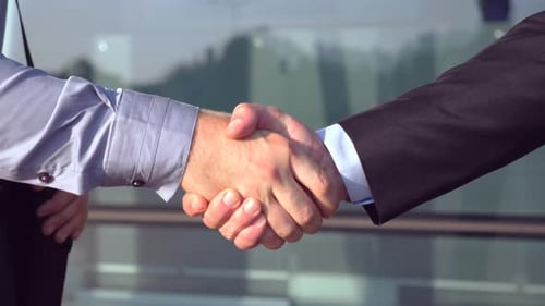 Close Up of Successful Businessmen Greeting Each Other Near Office Building