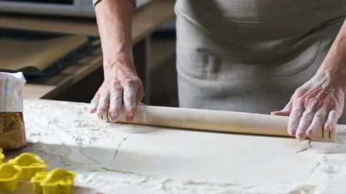 Adult Hands Roll Dough with Flour in Kitchen